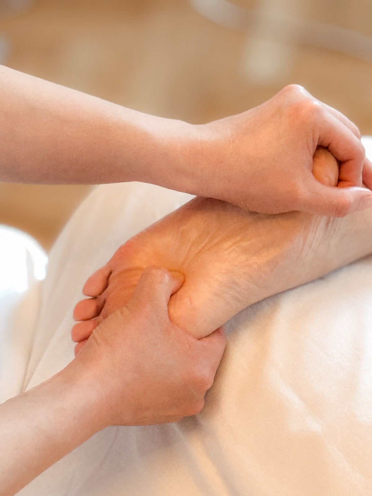 Gezielter Druck mit der Hand auf einen Punkt am Fuß